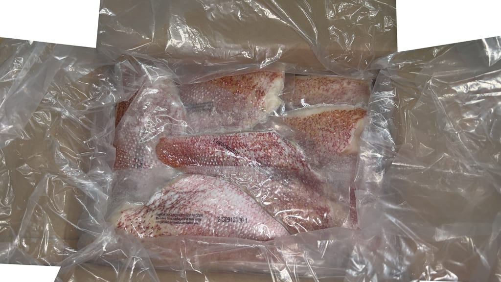 Skin on Red emperor fillets individually vacuum packed in carton on white background