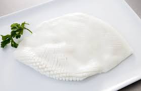 Pineapple cut squid on a white plate with a sprig of parsley