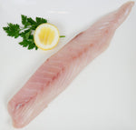 Ribaldo fillet sitting on plate alongside lemon and parsley garnish